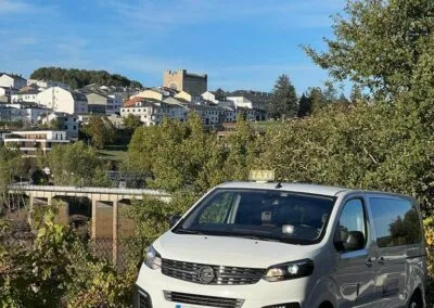 Foto de Portomarín tomada desde lejos para que puedas ver el puente y parte del pueblo. Nuestro taxi aparcado, esperando para llevarte o traerte donde necesites.